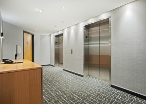 Two passenger elevator doors in the reception area of an office