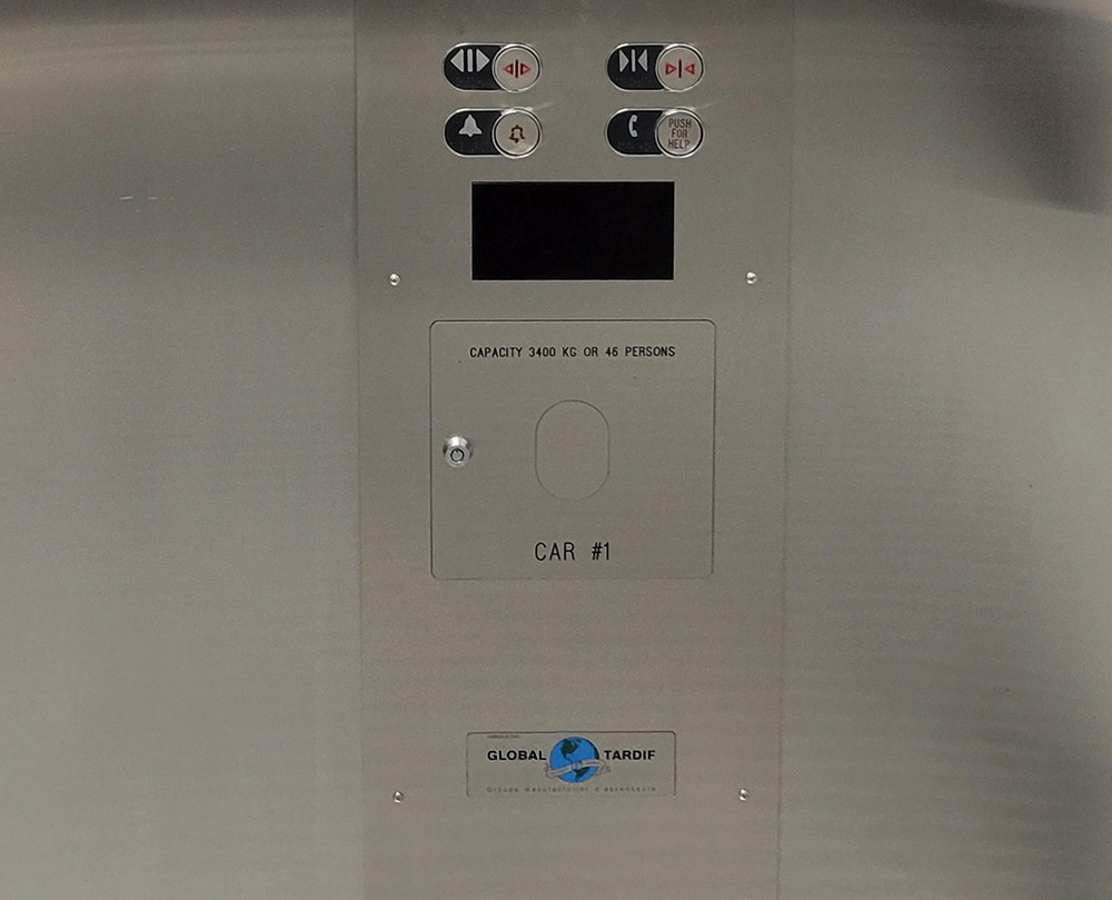 The door open and close buttons on the elevator car control panel.