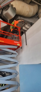 elevator technician servicing an oil cooler for a hydraulic freight elevator.